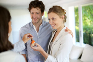A couple receiving house keys, representing a stable rental property investment.
